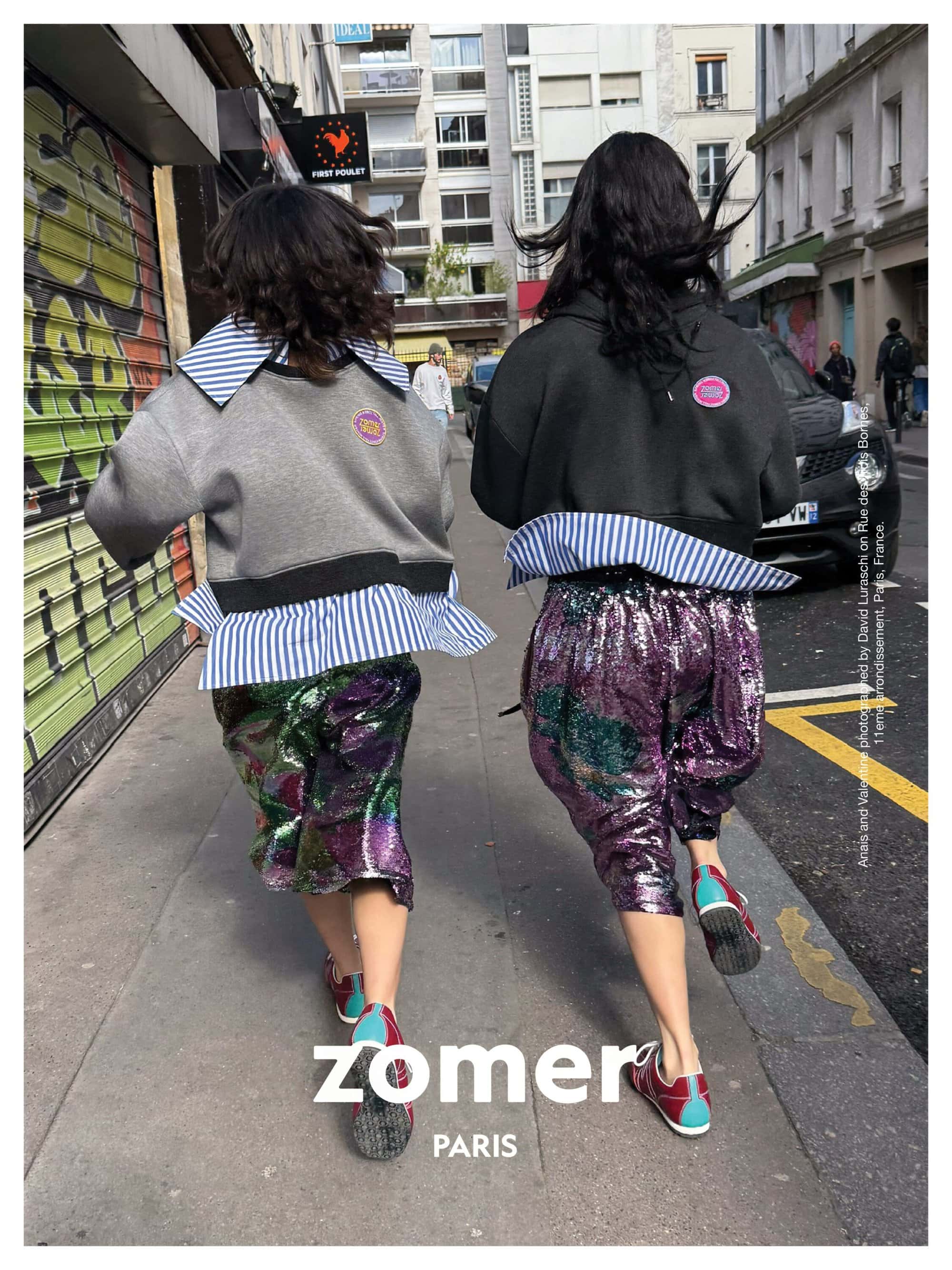 Two models running down a city street wearing distinctive layered tops and sequined trousers for Zomer Fall 2025 campaign.