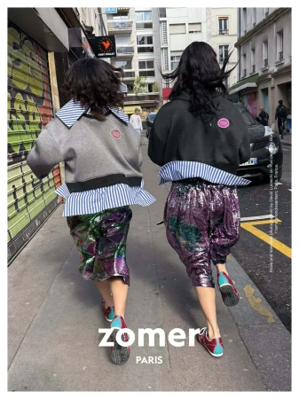 Two models running down a city street wearing distinctive layered tops and sequined trousers for Zomer Fall 2025 campaign.