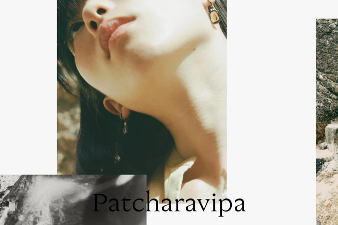 Close-up low-angle portrait of a person wearing sculptural earrings with visible typography reading Patcharavipa.
