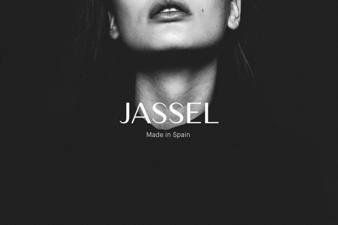 Monochrome close-up portrait of a woman chin and lips against a dark background with white brand typography
