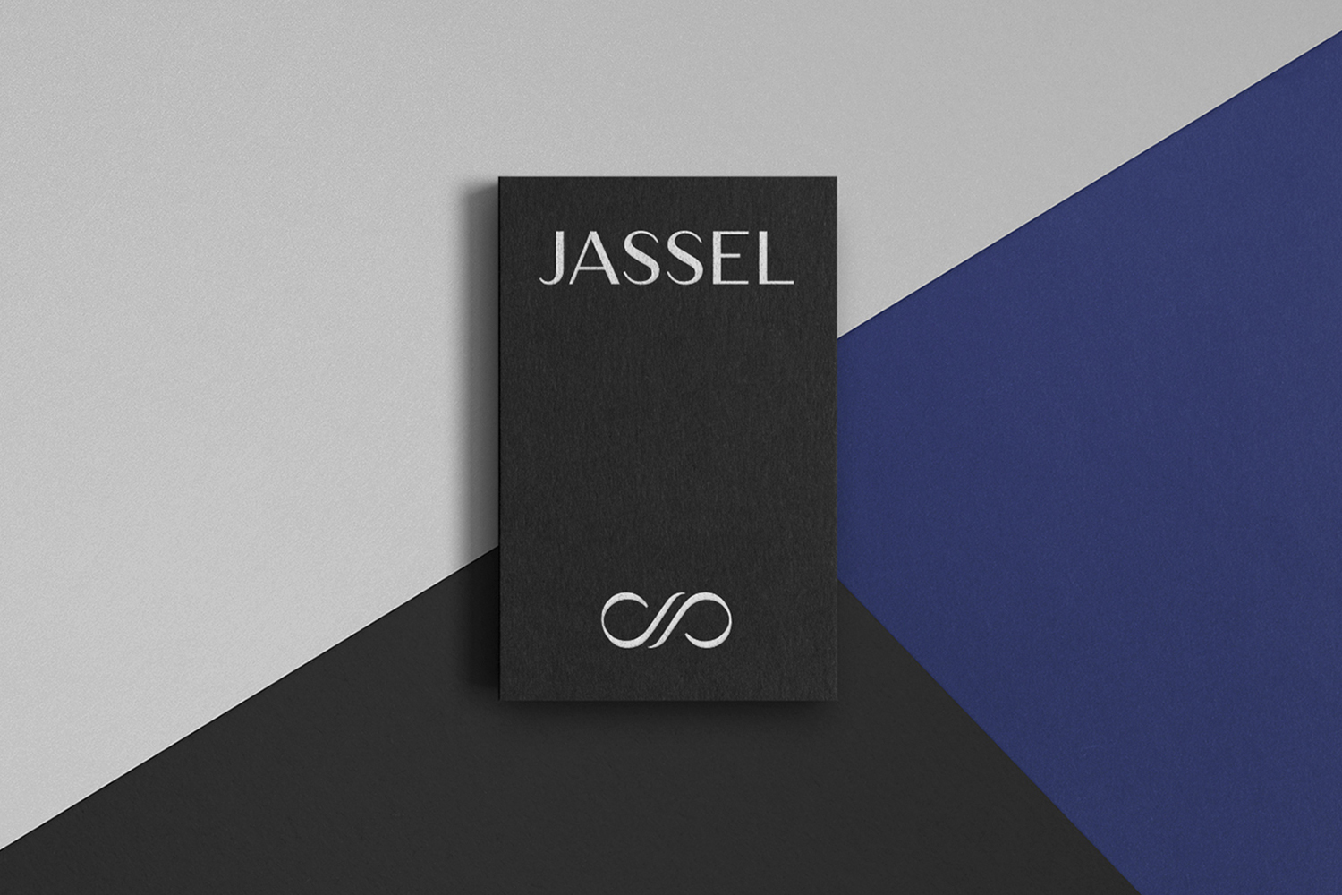 Black rectangular Jassel brand identity card placed on a geometric background of grey and royal blue shapes.