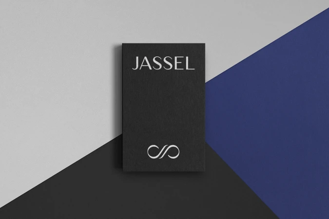 Black rectangular Jassel brand identity card placed on a geometric background of grey and royal blue shapes.