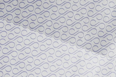 Close-up of patterned white tissue paper featuring a repeating purple monogram motif arranged in diagonal rows.