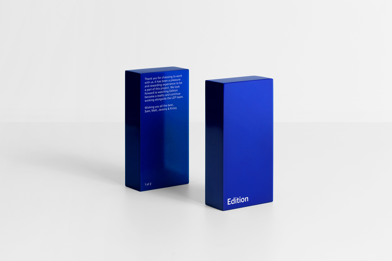 Two glossy rectangular blue boxes displaying white text against a white seamless background