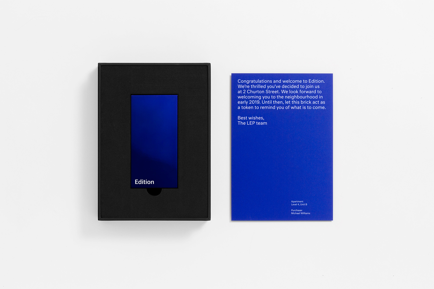 Blue card and black boxed object resting on a white surface for a brand identity design by Studio South.