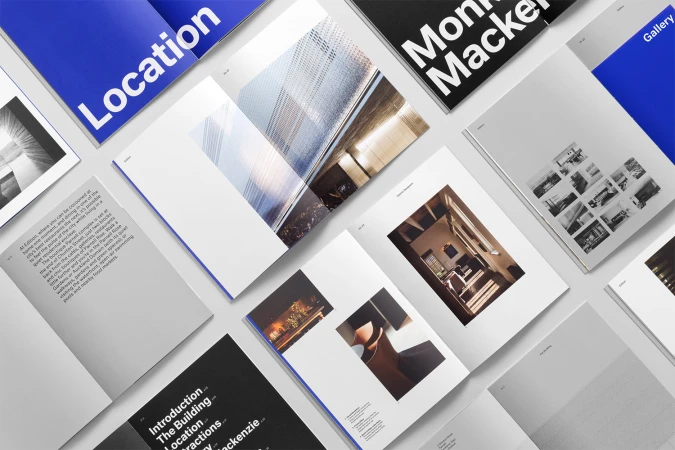 Flat lay photograph showing multiple open brand identity brochures and editorial spreads with minimalist typography and architectural photography.
