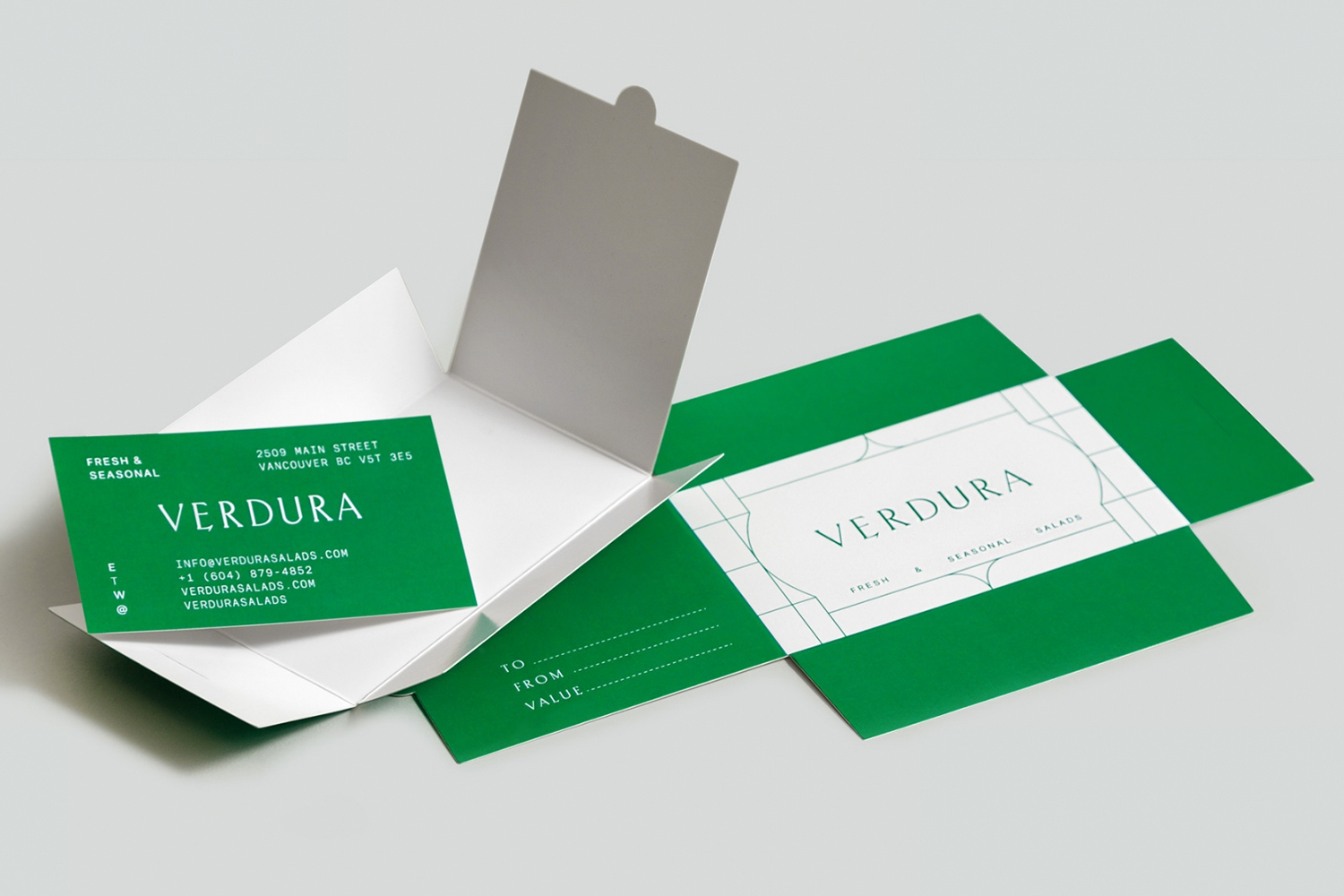 Verdura brand identity packaging with a green business card inside an open white box beside a green layout panel on a light grey background