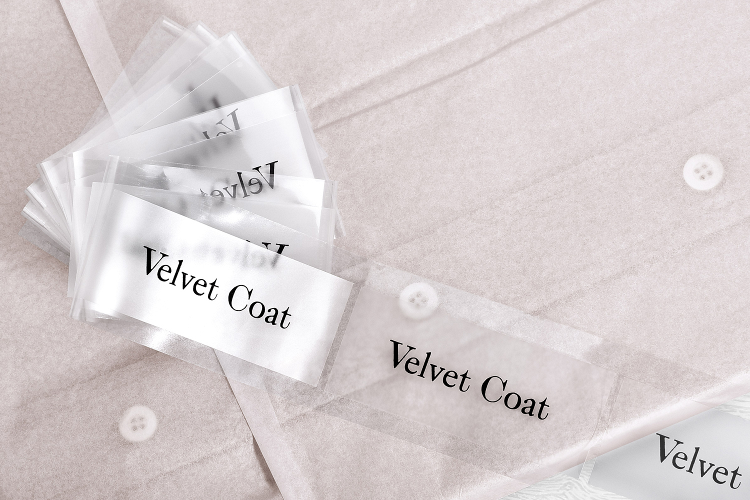 Stacked translucent packaging pouches with Velvet Coat branding on a light textured background