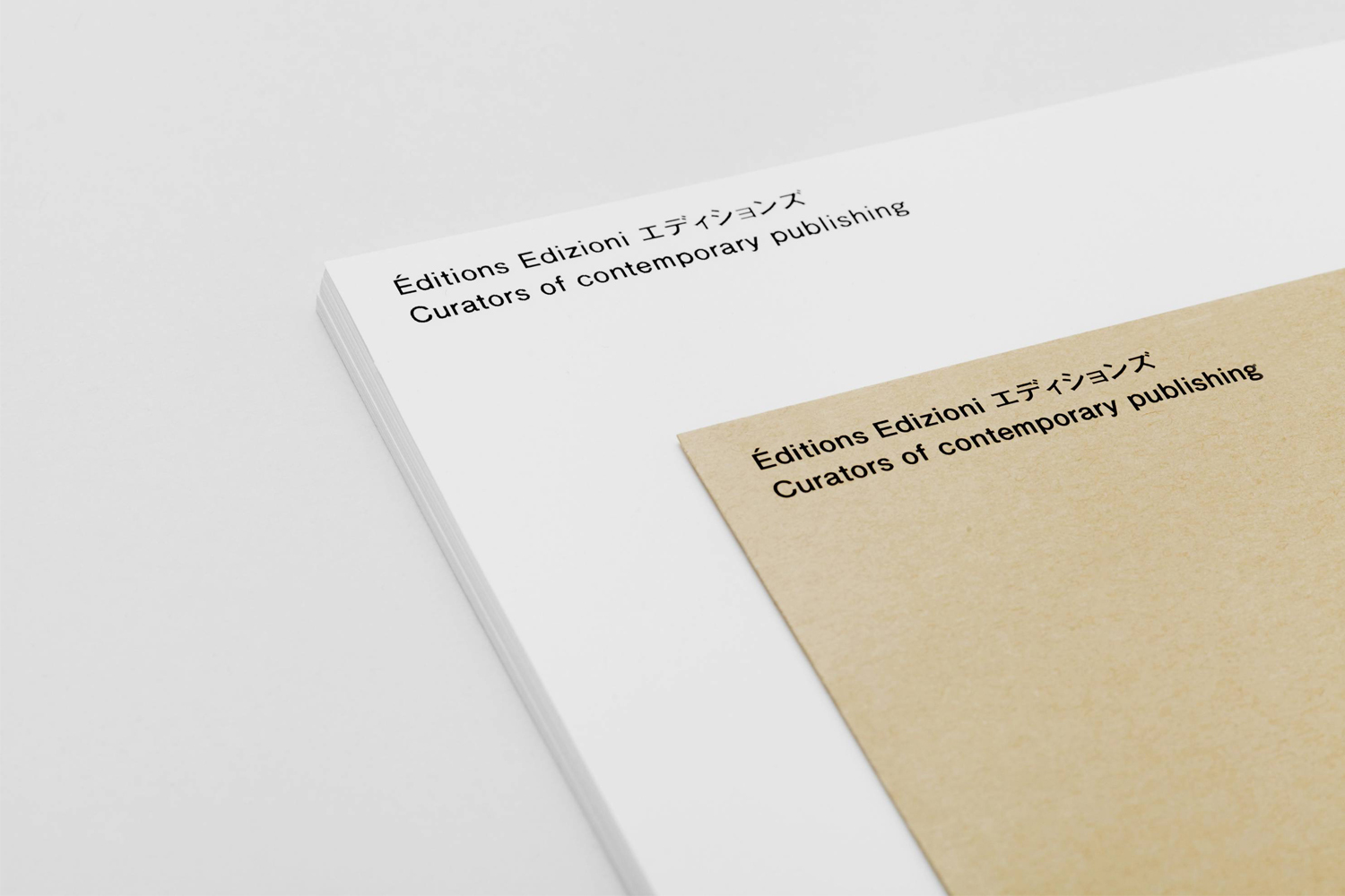 Close-up of stacked white and kraft paper publications with typography against a clean background