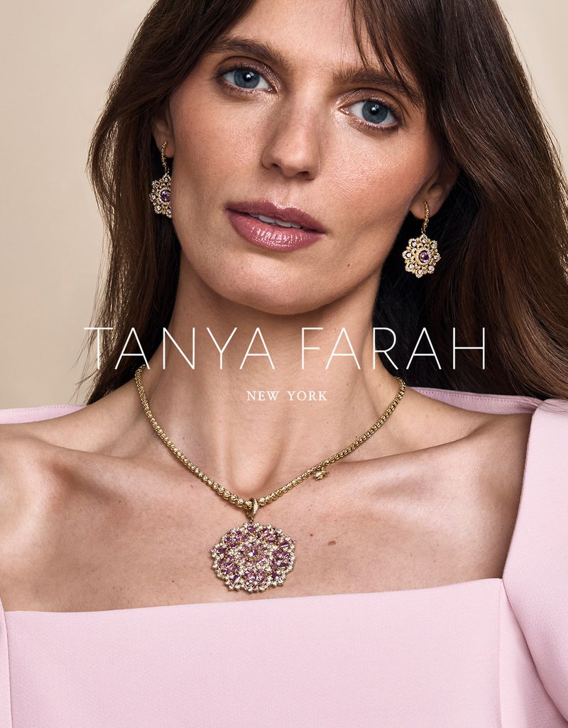 Close-up of a woman wearing a gold necklace with a flower pendant and matching earrings for Tanya Farah New York jewelry brand.