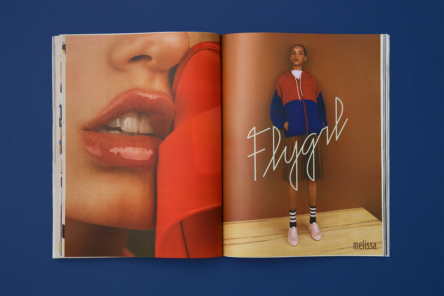 Open magazine spread showing a close-up portrait of lips on the left and a full-body model in a colorblock hoodie on the right.