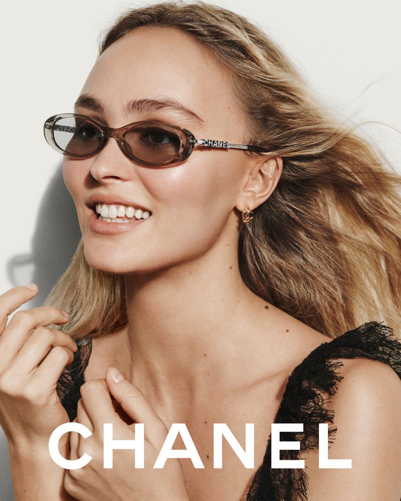 Lily-Rose Depp wearing oval sunglasses and a black lace top against a white seamless background for Chanel Eyewear S/S 2026.