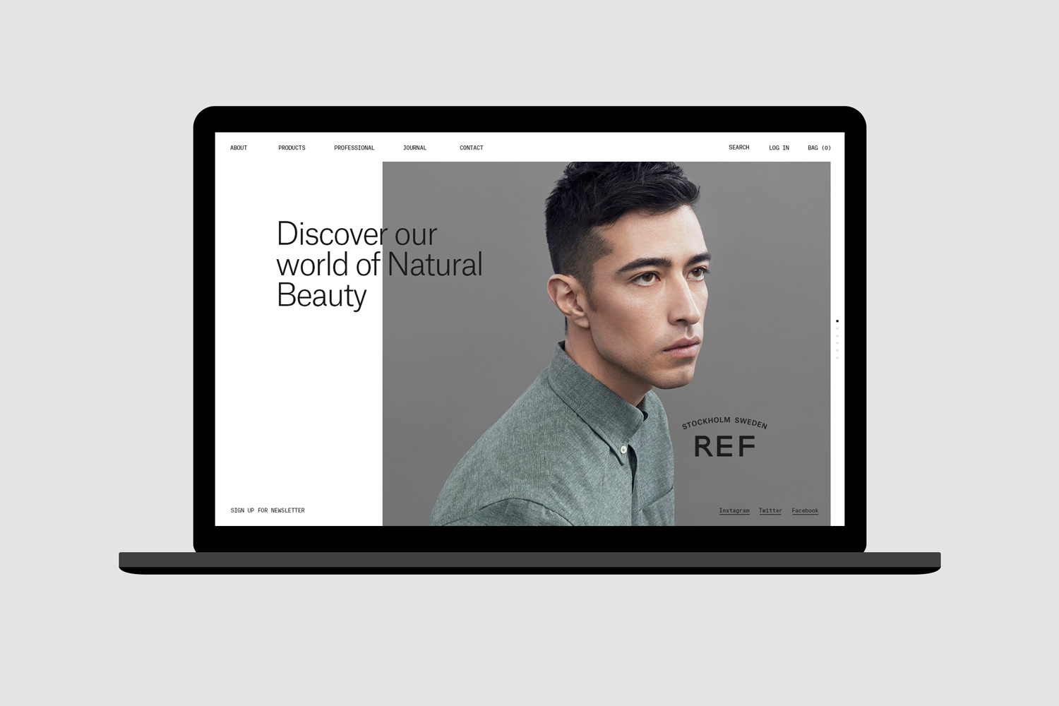 Laptop screen displaying the REF brand website homepage with a man wearing a green button-down shirt against a grey background.