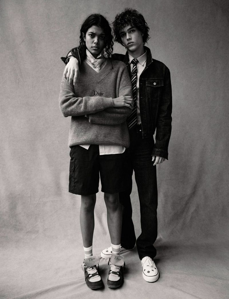Monochrome fashion editorial portrait of a woman and a man standing against a seamless backdrop