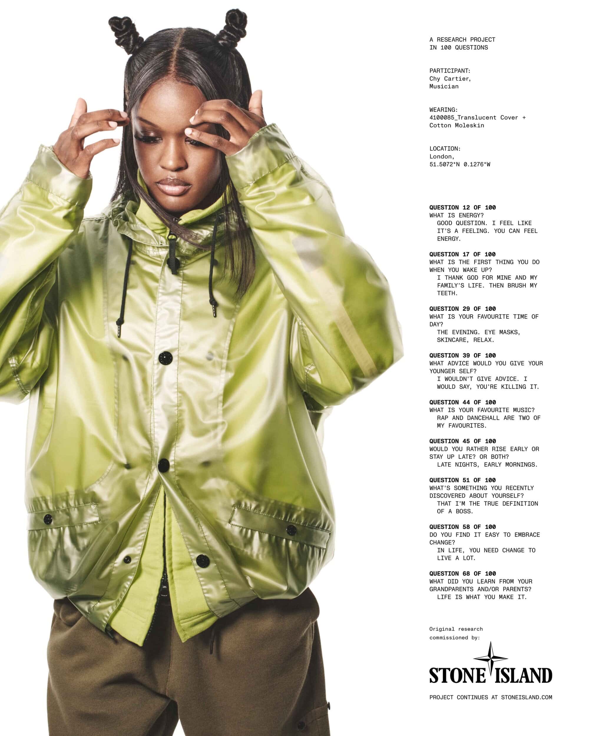 Chy Cartier wearing a translucent green jacket with hair styled in two top knots against a white seamless backdrop.