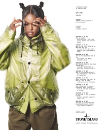 Chy Cartier wearing a translucent green jacket with hair styled in two top knots against a white seamless backdrop.