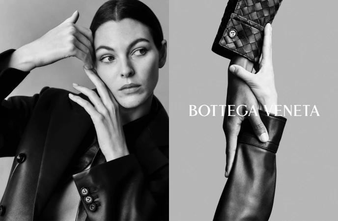 Black and white portrait of a woman wearing a dark blazer against a grey background for Bottega Veneta