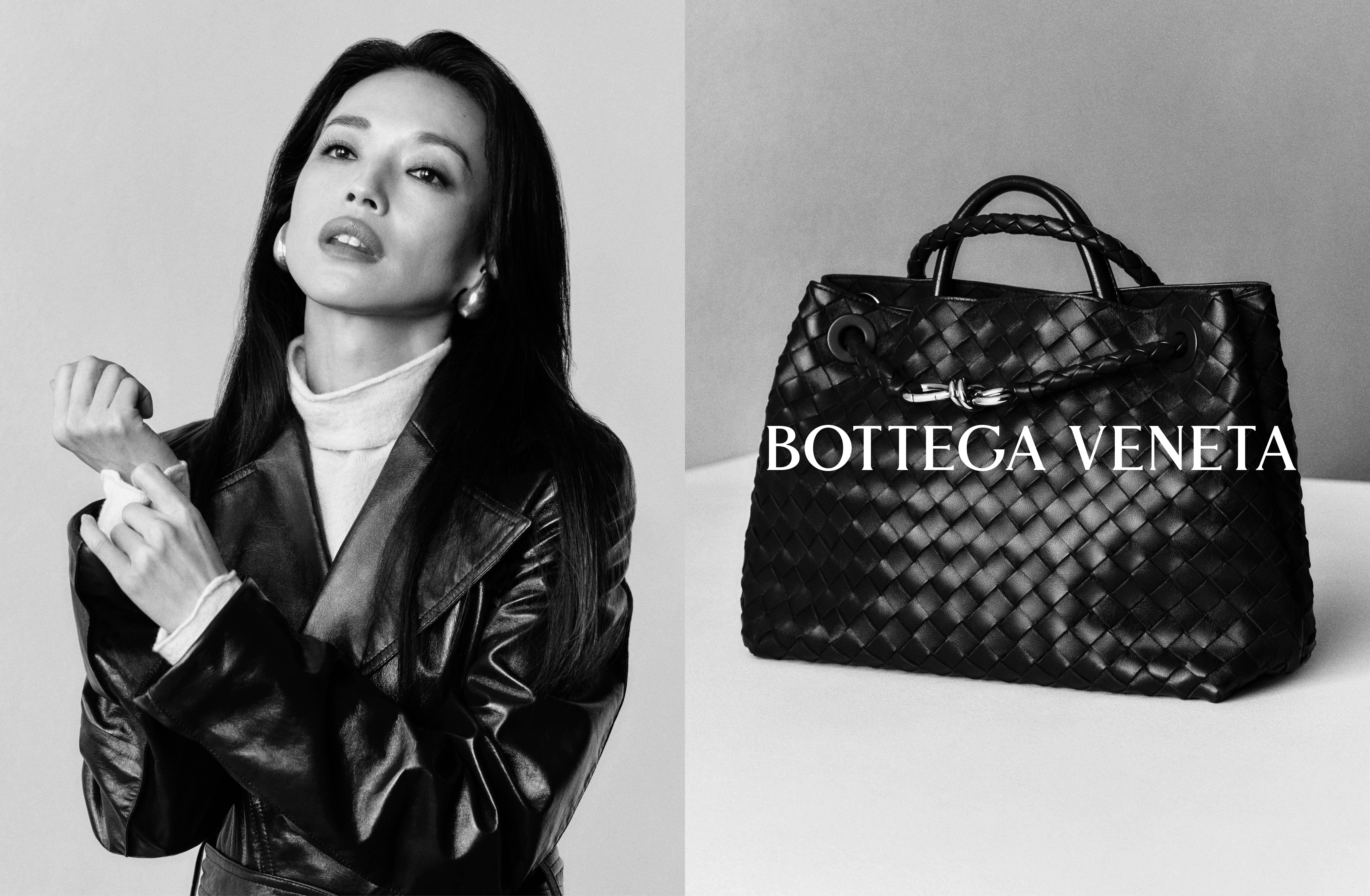 Black and white ad image showing a woman adjusting her leather coat sleeve and a woven leather handbag with Bottega Veneta text.