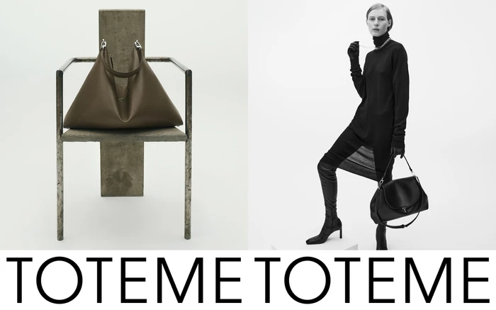Model in black turtleneck and tall boots standing beside a sculptural metal chair holding a leather handbag against white