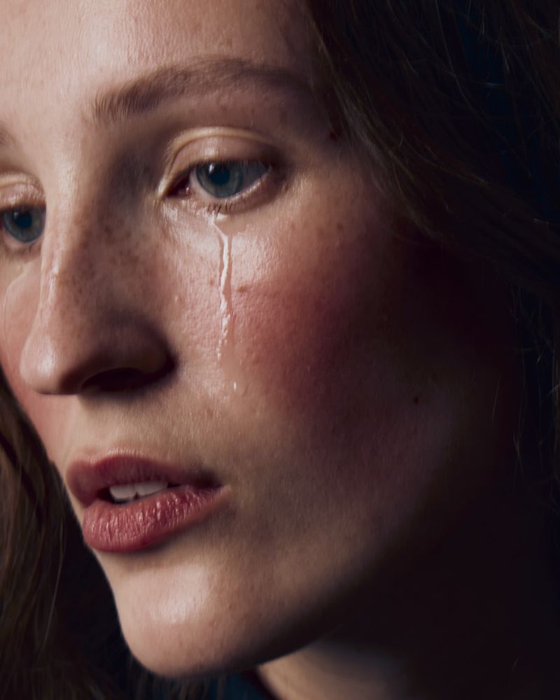 Close-up portrait of a woman with a single tear rolling down her cheek for Vogue Portugal editorial