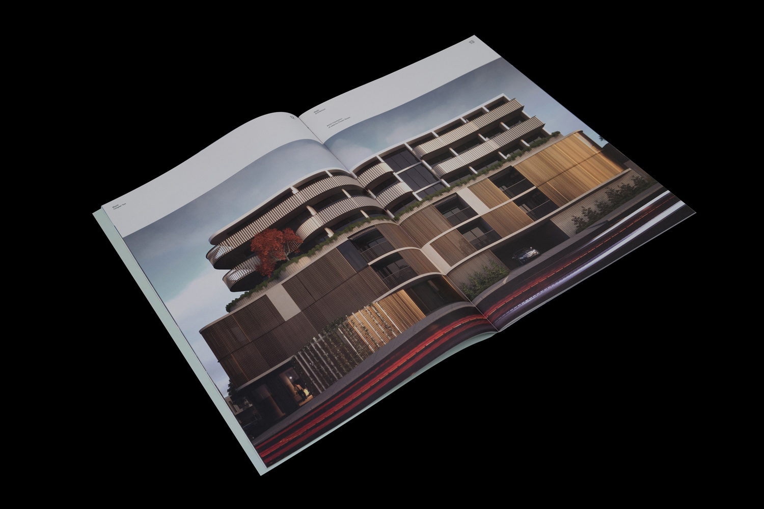 An open printed brochure showing architectural renderings of modern apartment buildings against a black background.