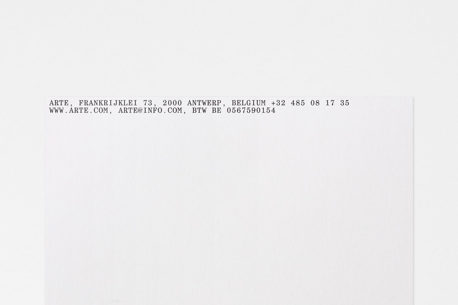 Typewritten company address text printed on white paper stationery for Arte brand identity
