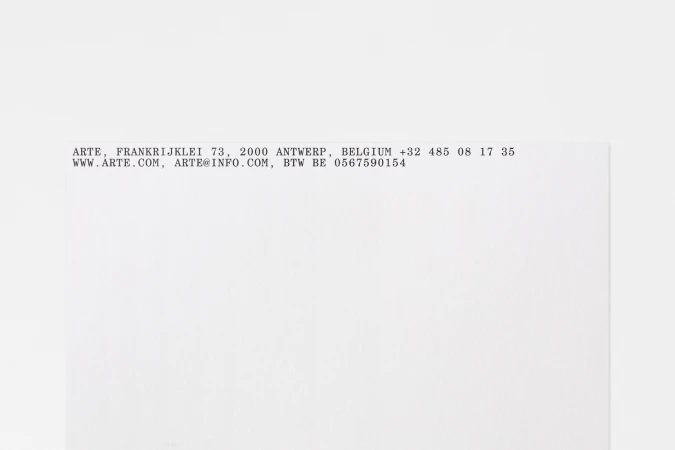 Typewritten company address text printed on white paper stationery for Arte brand identity