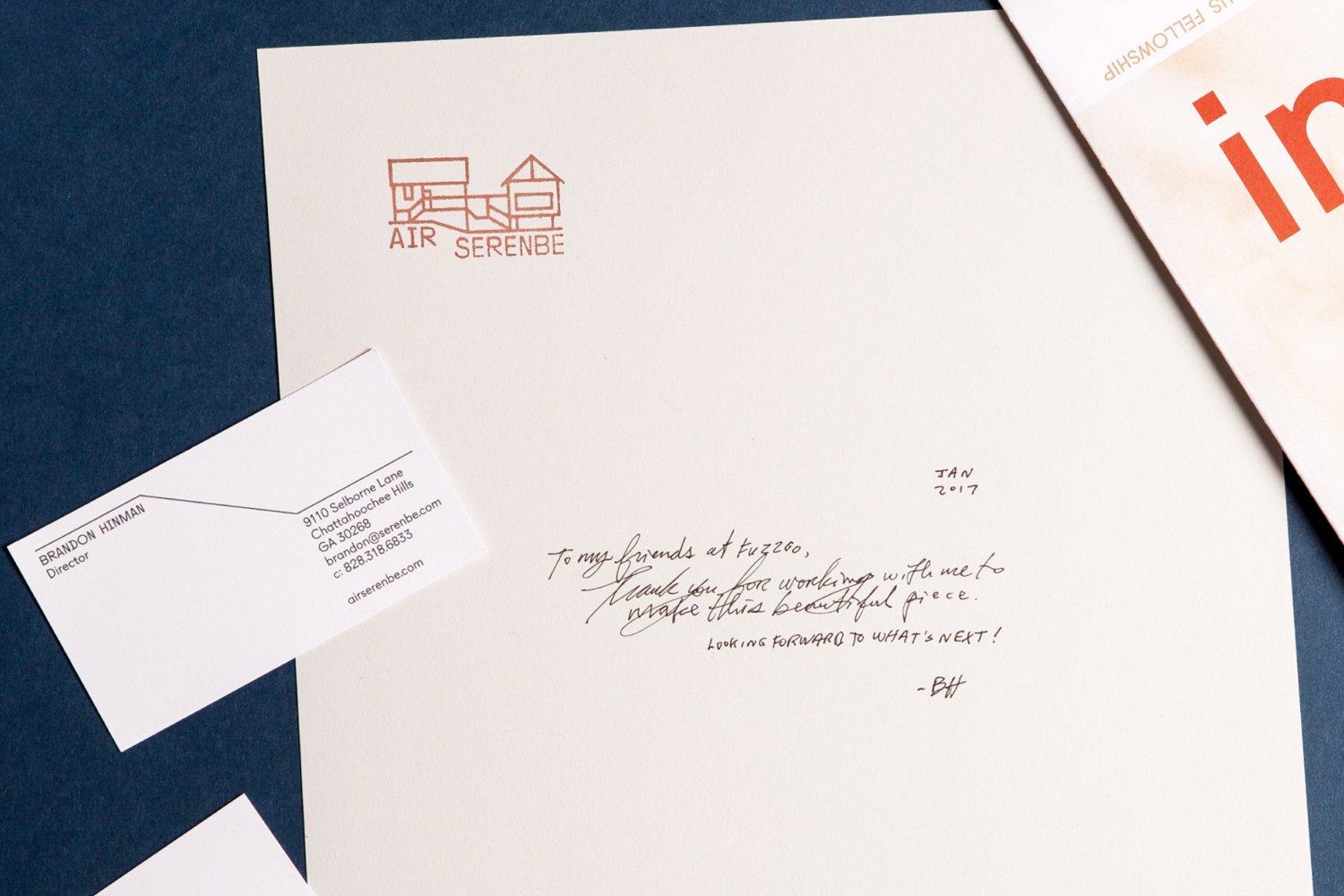 Branded stationery set featuring AIR Serenbe business card and letterhead on a dark blue surface