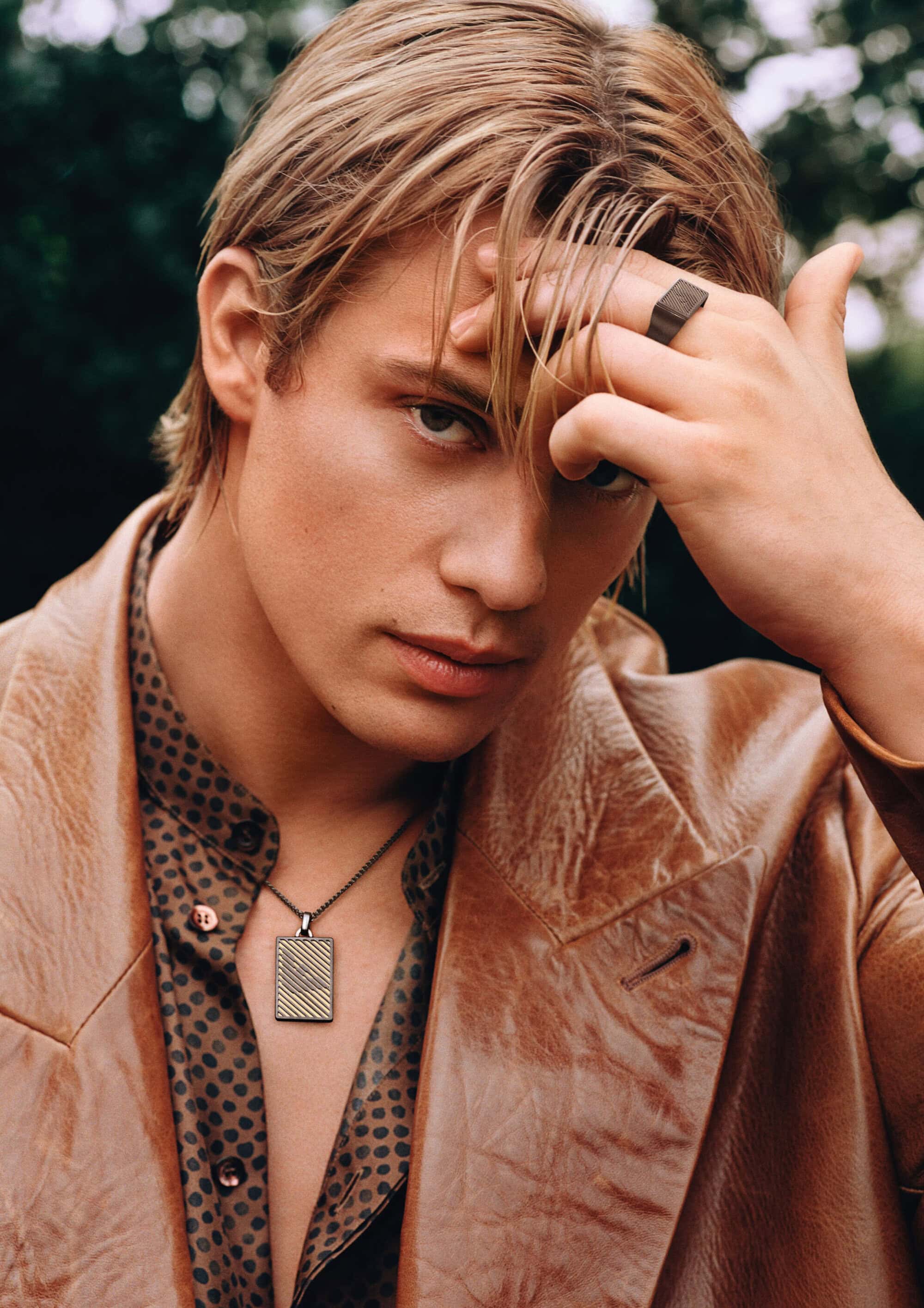 Nicholas Galitzine wearing a brown leather jacket and patterned shirt for Emporio Armani