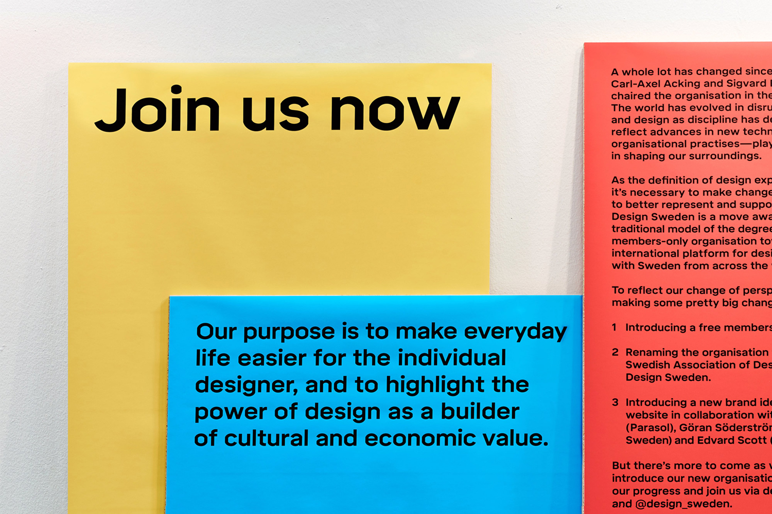 Close-up shot of yellow, blue, and red rectangular panels featuring bold black typography for Design Sweden's brand identity.