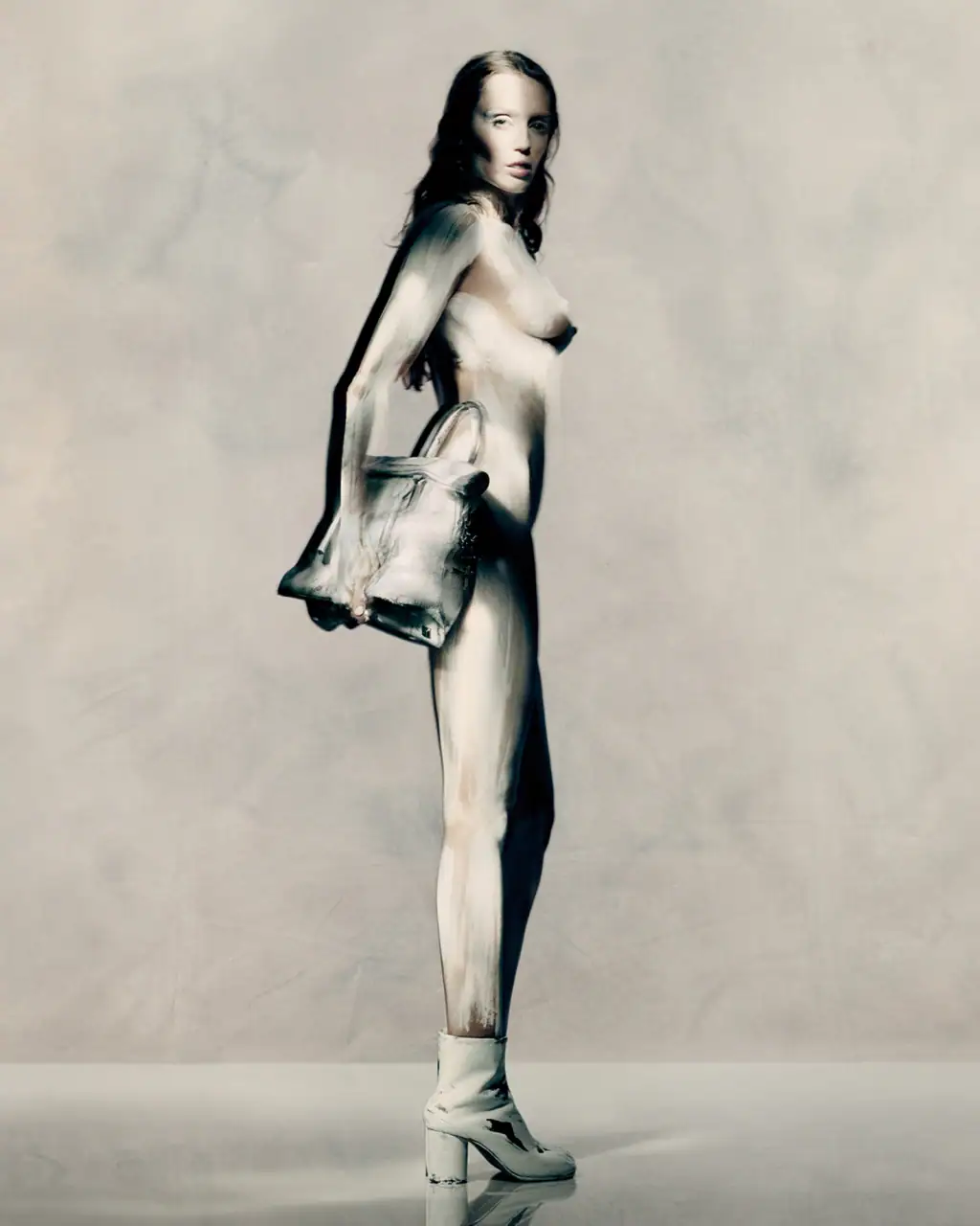 Model Miley Cyrus wearing white heeled boots and holding a handbag in Maison Margiela Fall 2025 ad campaign