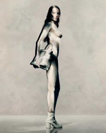 Model Miley Cyrus wearing white heeled boots and holding a handbag in Maison Margiela Fall 2025 ad campaign