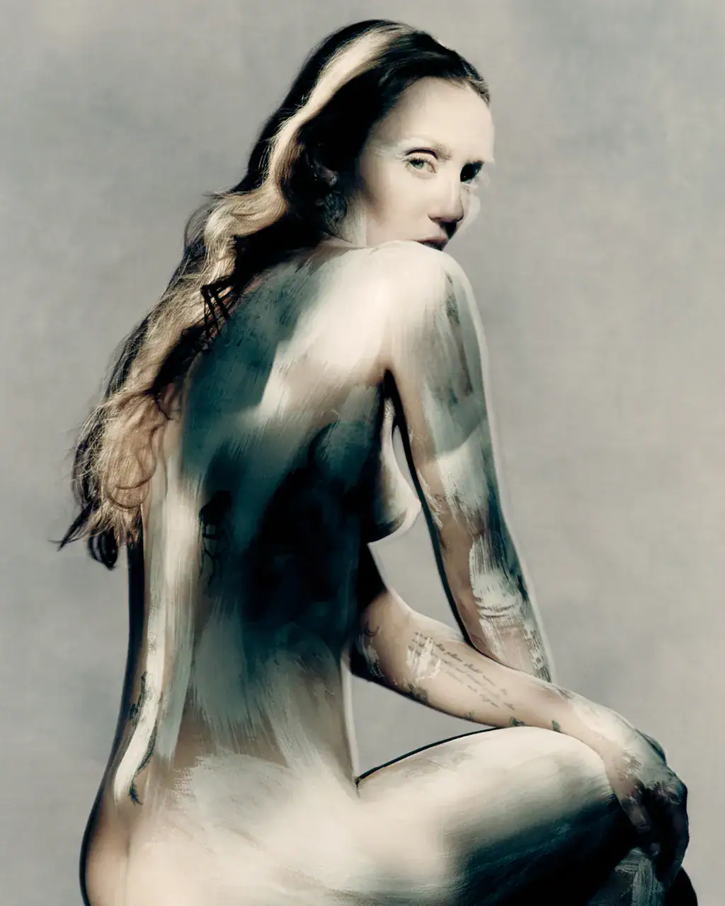 Miley Cyrus posed in profile for Maison Margiela Fall 2025 ad campaign with painted body and dramatic studio lighting against a grey backdrop.