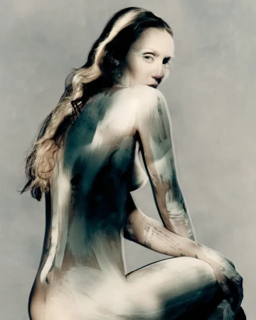 Miley Cyrus posed in profile for Maison Margiela Fall 2025 ad campaign with painted body and dramatic studio lighting against a grey backdrop.