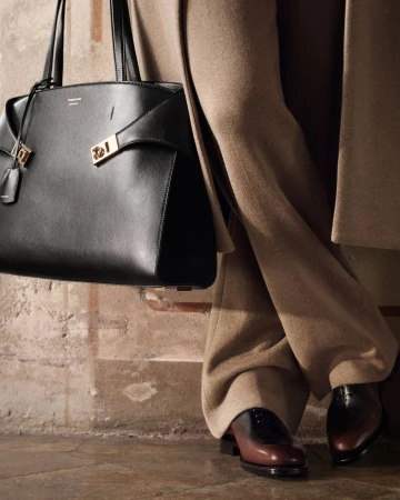 Close up of black leather handbag and tailored trousers from Ferragamo Fall 2025 campaign shot by Craig McDean.