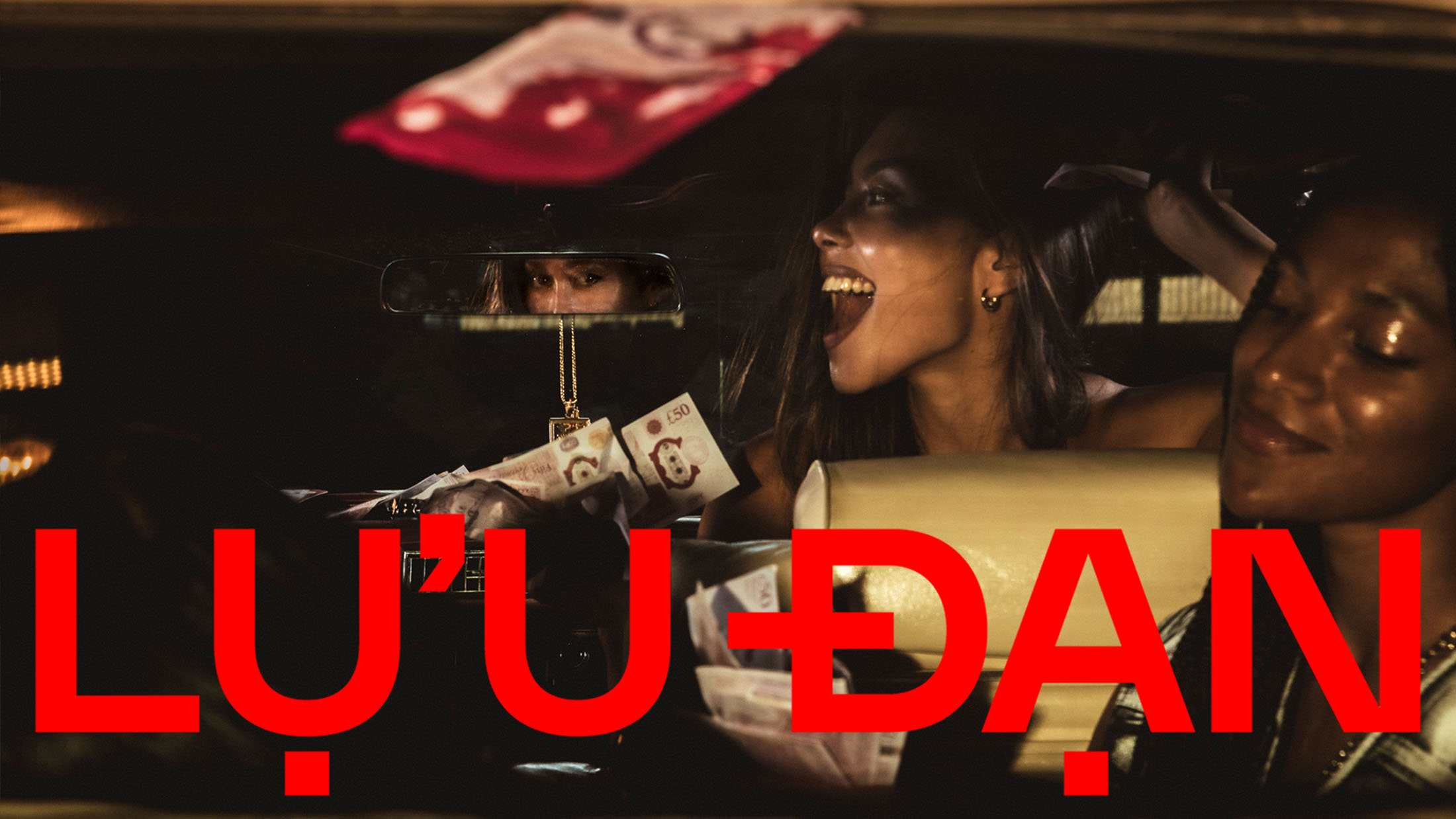 People inside a car with visible cash in low-light interior for Lu'u Dan campaign