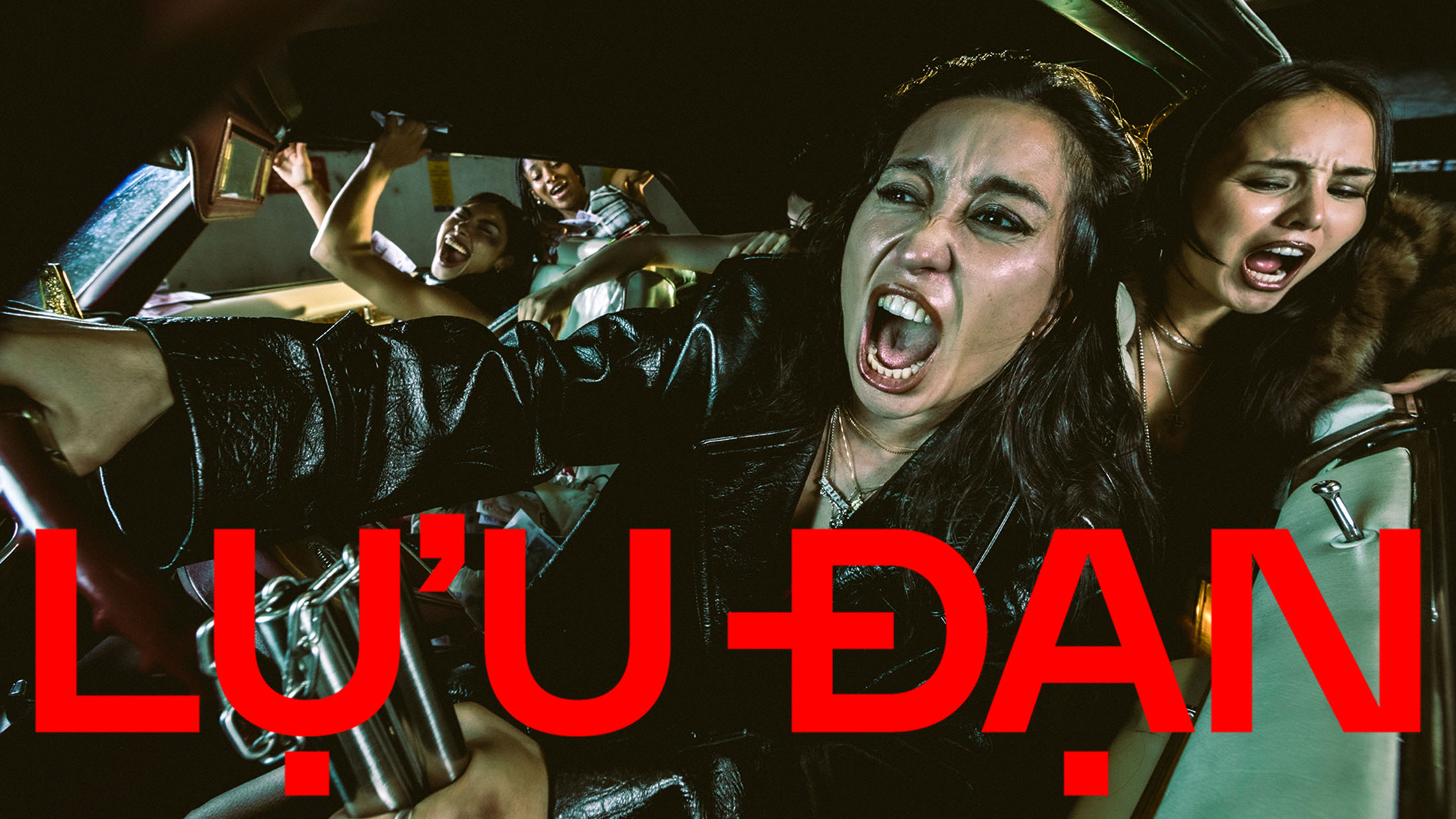 Several women screaming and reacting intensely inside a moving car at night for the Lu'u Dan Fall 2025 campaign.