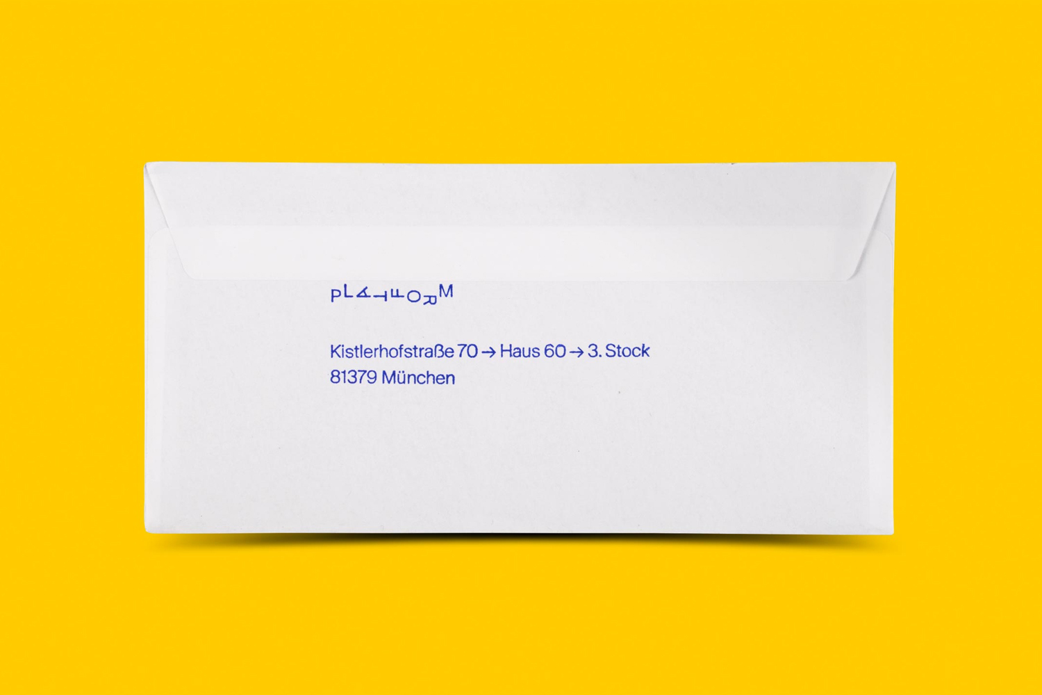 White paper envelope featuring blue printed text resting on a vibrant yellow background.