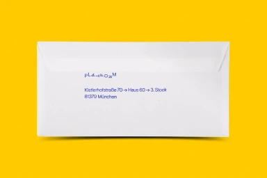 White paper envelope featuring blue printed text resting on a vibrant yellow background.
