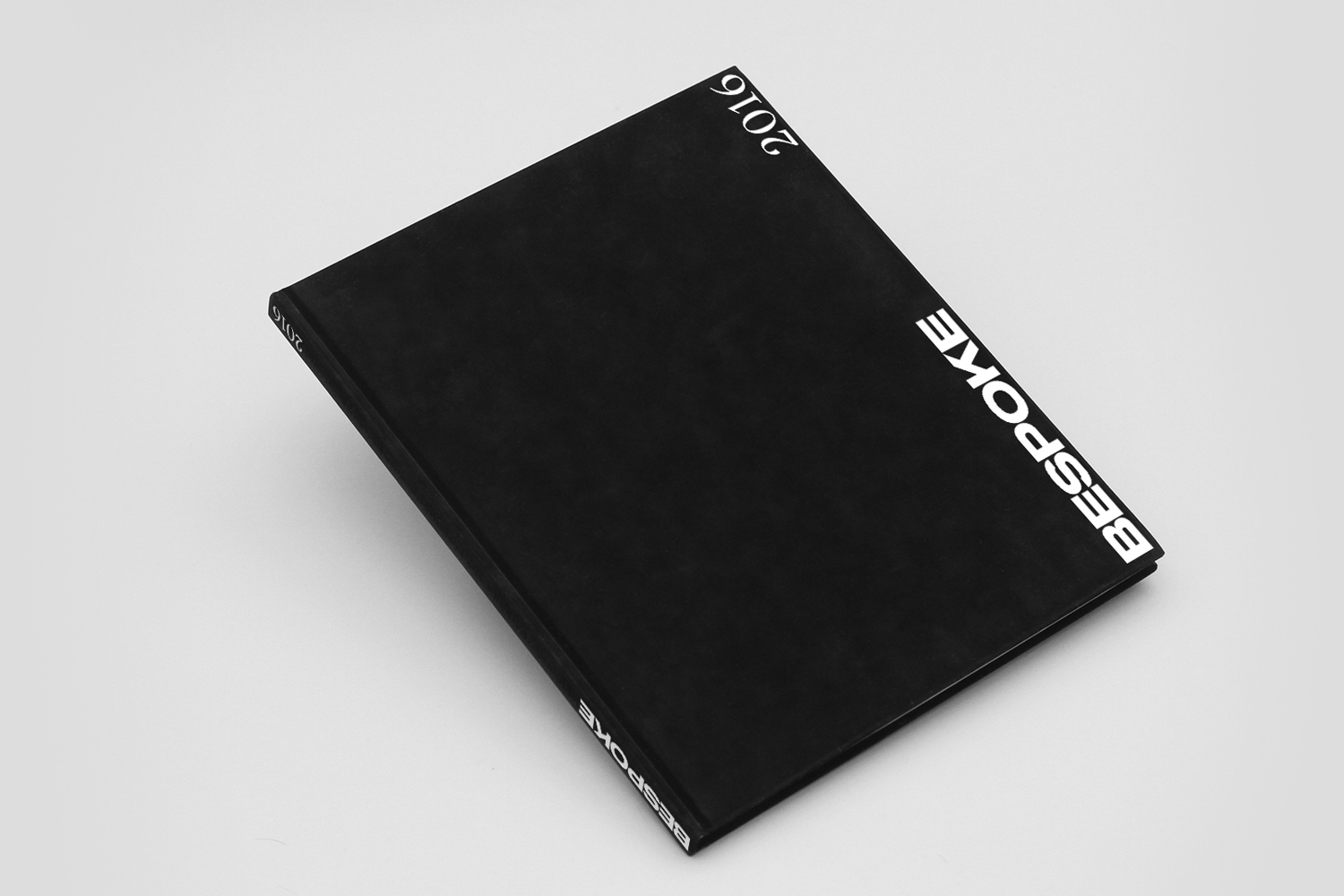 Black bound book featuring bold white Bespoke typography set diagonally against a minimal white background