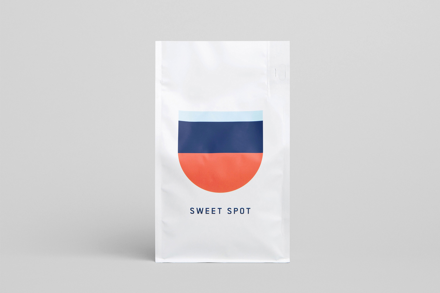White Deluca Coffee pouch featuring a minimal geometric logo with blue and orange stripes on a grey background.
