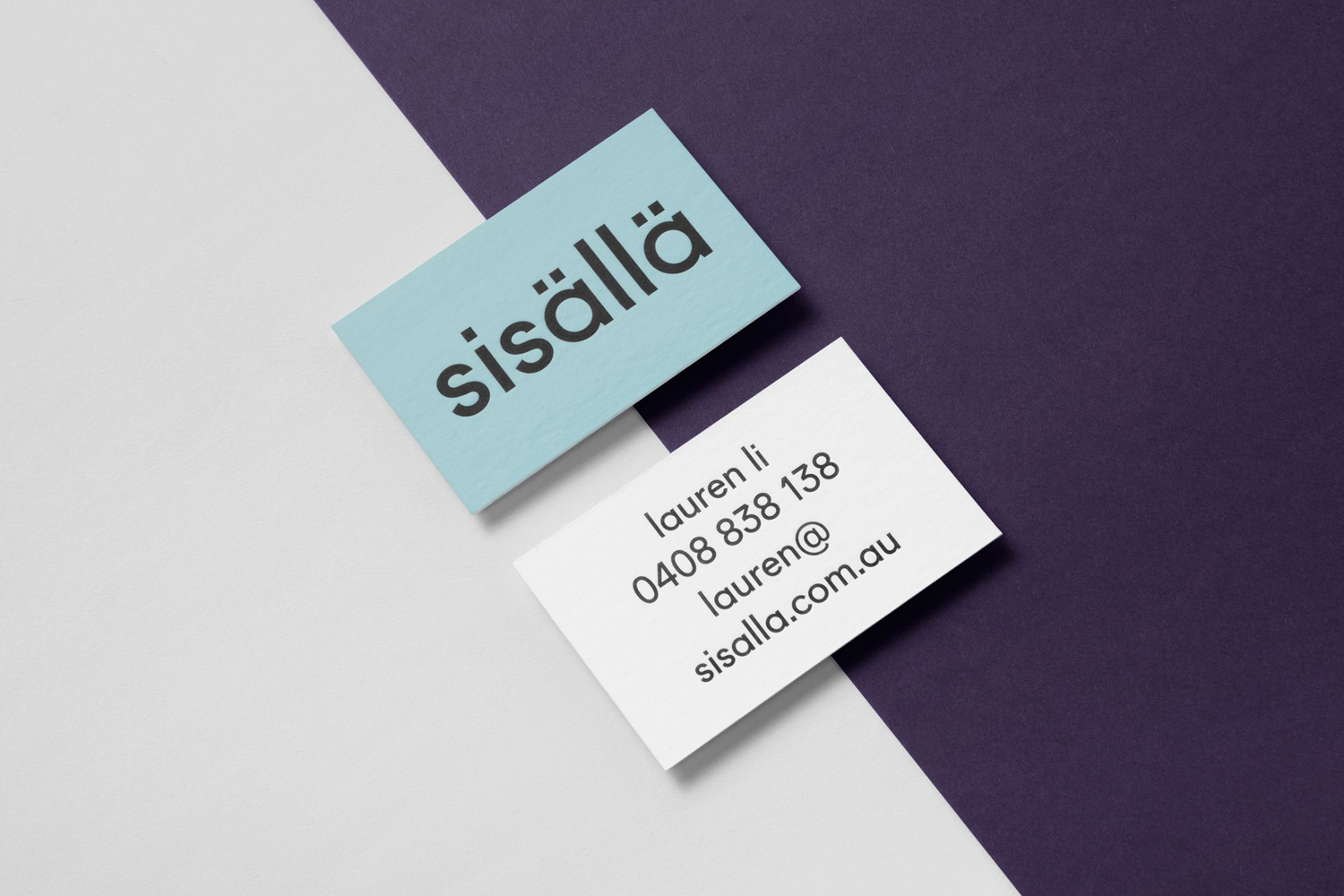 Two business cards for Sisalla featuring brand identity design displayed on a diagonal split background of white and purple.