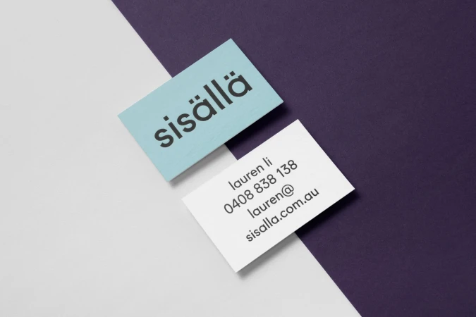 Two business cards for Sisalla featuring brand identity design displayed on a diagonal split background of white and purple.