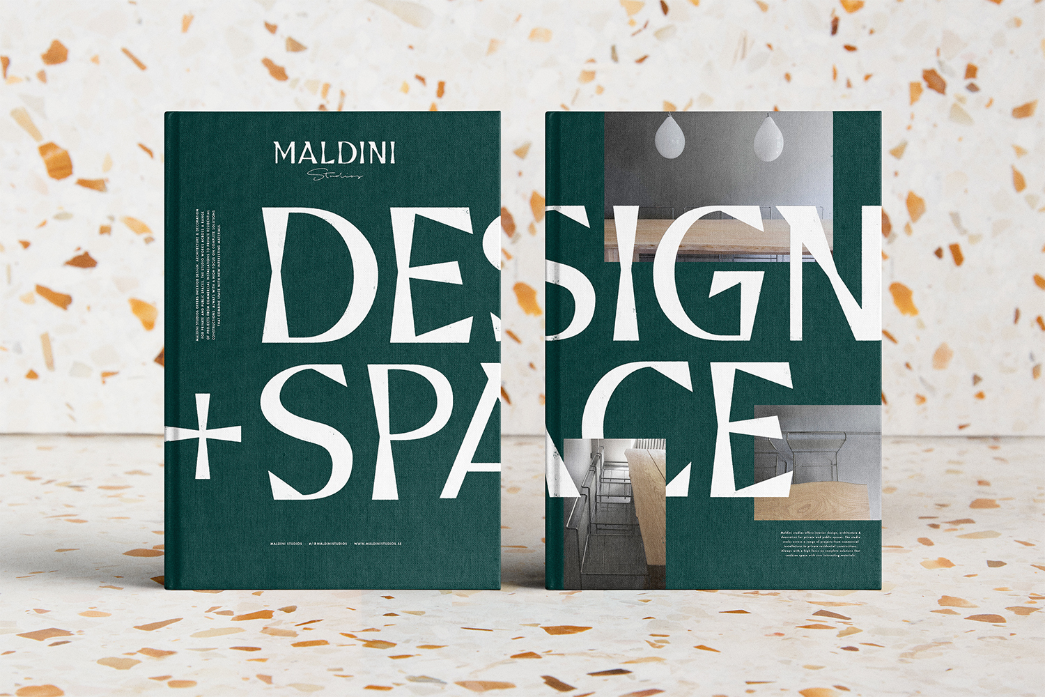 Two dark green hardcover books featuring large white typography reading design space set against a speckled terrazzo surface