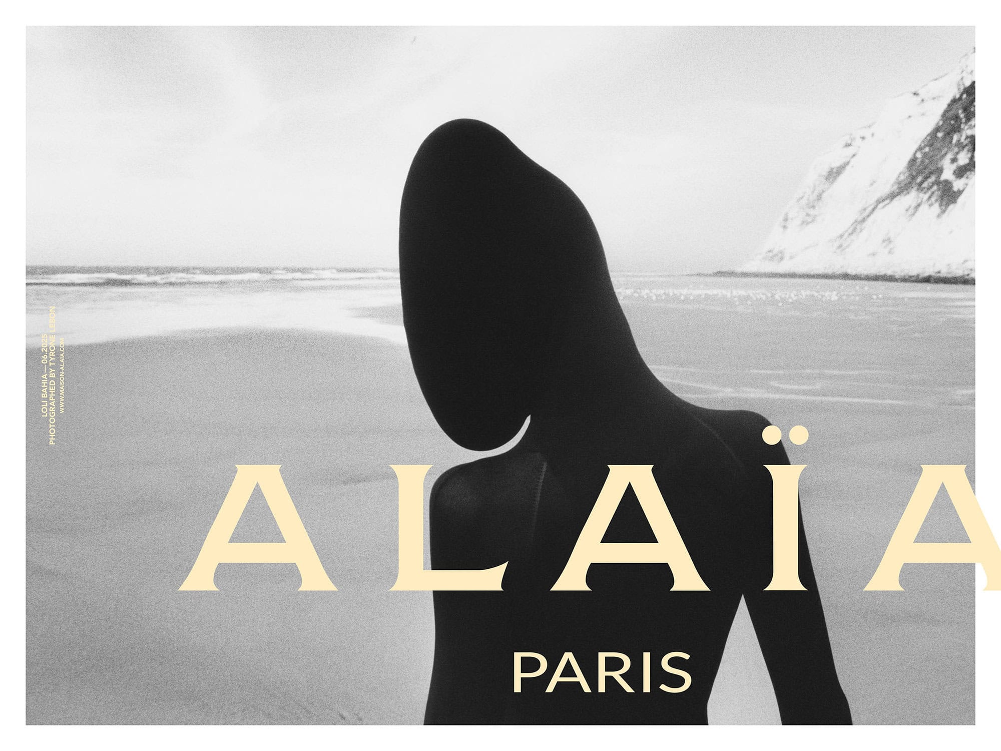 Model silhouetted against a sandy beach and ocean under an overcast sky for Alaïa Fall 2025 campaign.