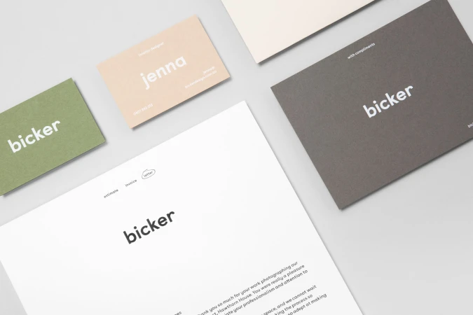 Flat lay of Bicker brand identity stationery including business cards and letterhead on a light grey surface.