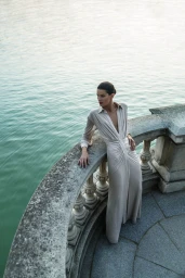 Model Isabeli Fontana leaning on a stone balustrade above water for BCBGMAXAZRIA Fall 2025 campaign, photographed by Juankr.