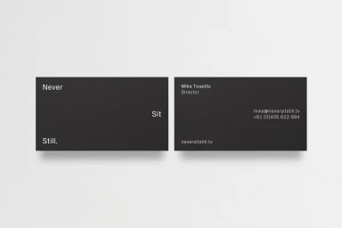 Two black business cards featuring minimalist white typography set against a clean white background surface.