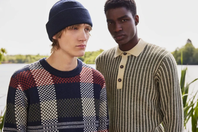 Two male models in patterned knitwear posing outdoors near a body of water for Ben Sherman campaign