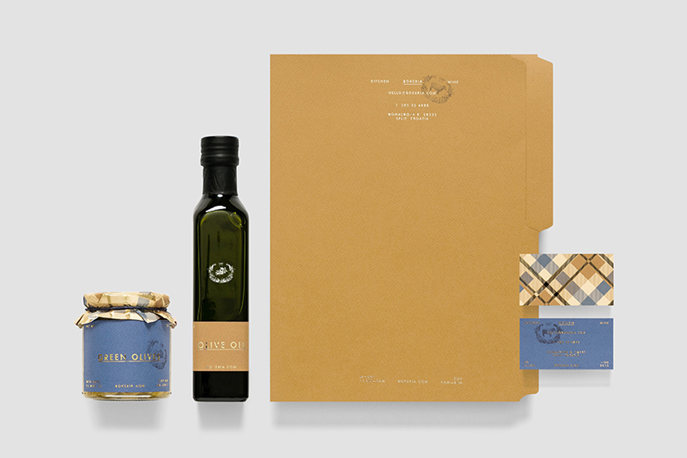 Bokeria brand identity stationery and packaging featuring a glass olive oil bottle, jar of green olives, folder, and business cards.